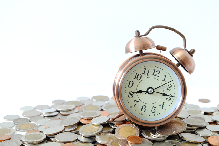 Clock on the pile of money White background