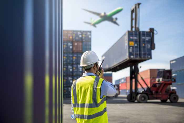 Foreman control loading Containers box from Cargo freight ship