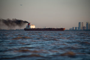 Cityscape South America. Cargo ship generating Pollution.