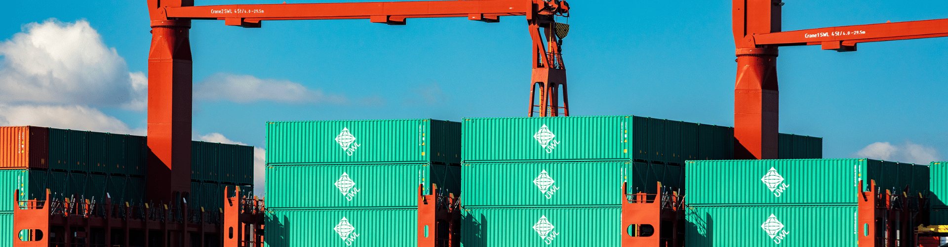 UWL containers stacked on a vessel beside port cranes