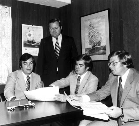 World Shipping Founder Jack Hunger and team in a conference room in the 1980s