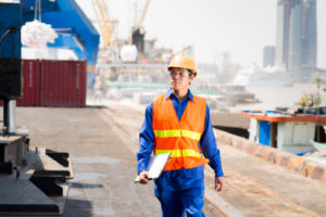 Serious dock worker controlling work process in the port